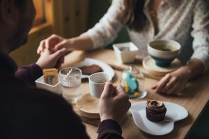 two people holding hands at a cafe