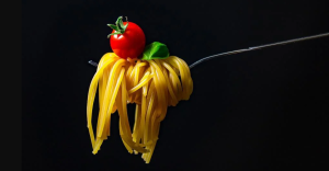 pasta on a fork with a tomato